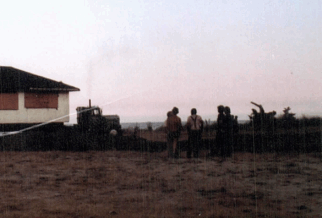 House on beach with people at sunset